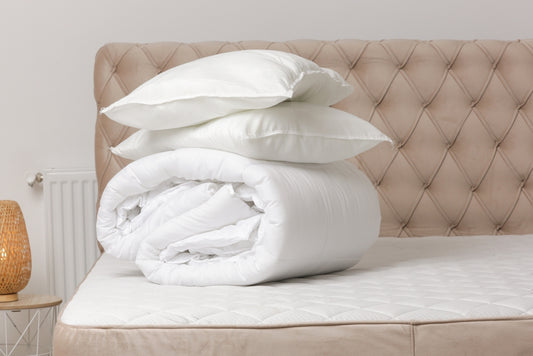 Soft folded duvet and pillows on bed